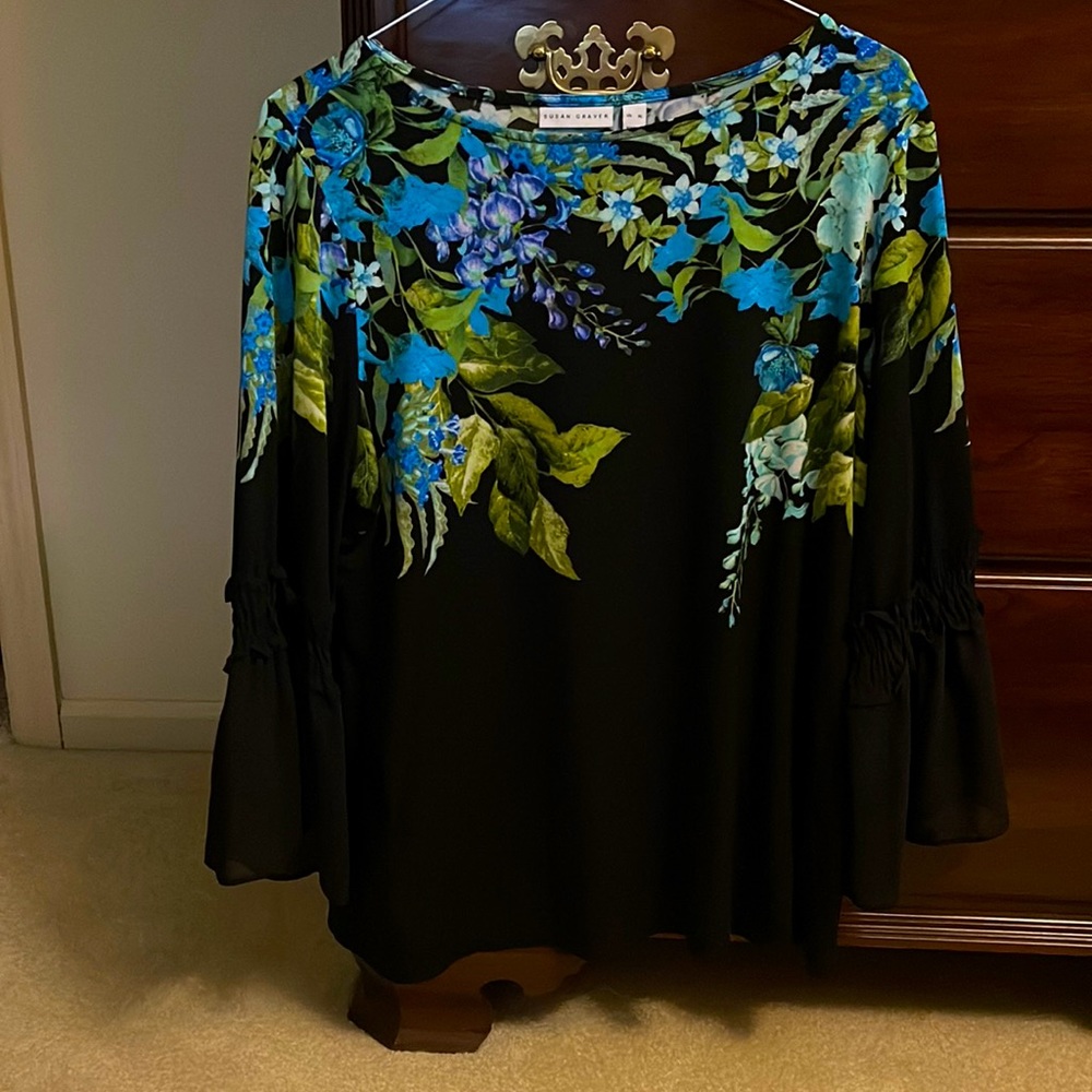 Black top with floral design around the neck and upper bodice.